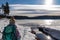 Woman with hiking backpack watching ducks on the frozen lake Forstsee, Techelsberg, Carinthia (Kaernten), Austria, Europe.