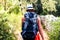 Woman hiking on country footpath with rock fence and woods.