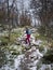 Woman hiking in forest of Pieljekaise National Park in autumn with snow in Lapland in Sweden
