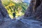 Woman hiking steep rocky mountain trail under cliffs