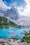 Woman hiking to blue green lake in the Italian Dolomites,Beautiful Lake Sorapis Lago di Sorapis in Dolomites, popular