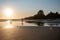 Woman and his dog enjoying a leisurely stroll along a beach at sunset