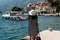 Woman hitchhiking on a pier. A girl is waiting for a boat on the pier