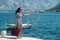 Woman hitchhiking on a pier. A girl is waiting for a boat on the pier