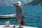 Woman hitchhiking on a pier. A girl is waiting for a boat on the pier