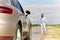 Woman hitchhiking and stopping car at countryside