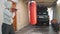 Woman Hitting Boxing Bag in Garage with Gloves