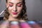 Woman hold make up pallete in the hands. Closeup of palette of an eye shadows in hands of a makeup specialist.