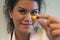 Woman hold medicine capsule with focus on the face