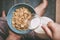 Woman hold sky blue colored bowl of tasty cereal corn flakes