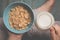 Woman hold sky blue colored bowl of tasty cereal corn flakes