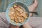 Woman hold sky blue colored bowl of tasty cereal corn flakes