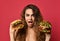 Woman hold two big beef burger sandwich and huge cheeseburger comparing with hungry mouth happy shouting on pink red