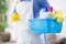 Woman hold washbowl with cleaning products