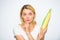 Woman hold yellow corncob on white background. Girl hold ripe corn in hand. Food vegetarian and healthy natural organic