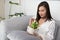 Woman holding air purifier tree in white pot.