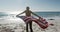 Woman holding American flag on the beach