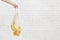 Woman holding Bananas and oranges in cotton reusable net bag