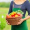 Woman holding the basket of her vegetable harvest