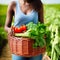 Woman holding the basket of her vegetable harvest