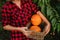 Woman holding a basket with orange pumpkins.