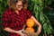 Woman holding a basket with orange pumpkins.