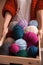 Woman holding a basket witn colorful yarn ball and knitting needles. Close-up vertical photo. Freelance creative working and
