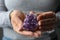 Woman holding beautiful violet amethyst gemstone