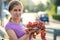 A woman holding big cluster of red juicy grapes in her hand