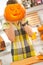 Woman holding a big Jack-O-Lantern pumpkin in front of head