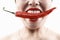 Woman holding big red chili in mouth