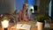 Woman holding bitcoins and thinking. Beautiful blond female sitting in dark room at desk with computer and lamp at night
