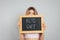 Woman holding blackboard with phrase Keto Diet on grey