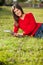 Woman Holding Books While Relaxing On Grass At