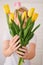 Woman holding a bouquet of spring festive tulips in her hands