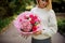 Woman holding bouquet of tender bright pink flowers