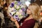 Woman holding a bouquet of tender purple, green and rosy color flowers in the wrapping paper