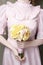 Woman holding bouquet of yellow carnation and pink roses