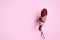 Woman holding bright foldable umbrella through hole in pink paper, closeup. Space for text