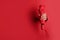 Woman holding bright umbrella through hole in red paper, closeup. Space for text