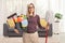 Woman holding a bucket with cleaning supplies and a cleaning mop in a living room