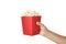 Woman holding bucket with delicious popcorn on white background