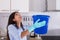 Woman Holding Bucket While Water Droplets Leak From Ceiling