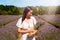 Woman holding a bunch of lavender in the middle of a lavender farm.