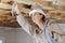 woman holding cables overhead in roofspace