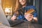 A woman holding and choosing credit cards while using laptop computer