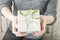 Woman holding christmas gift decorated with mistletoe twig