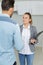 Woman holding clipboard and inspecting house with tenant