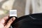 Woman holding clothing label on black garment, closeup