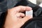 Woman holding clothing label on black garment, closeup